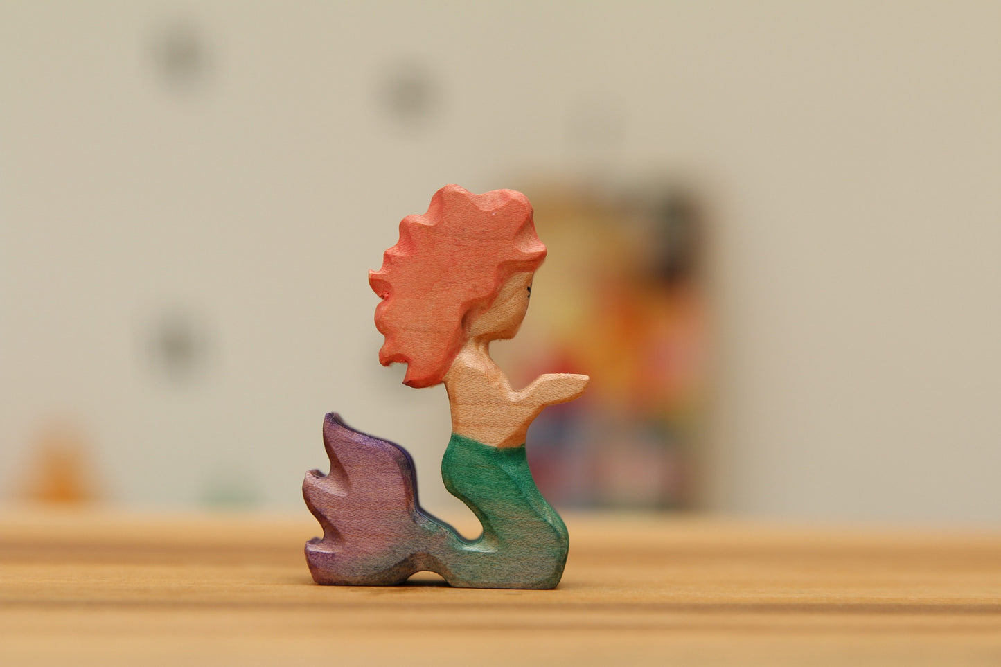 Kneeling Mermaid with strawberry blond hair and green/purple tail