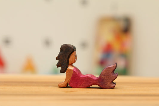 Reclining Cherry Mermaid with black hair and Pink/purple tail.