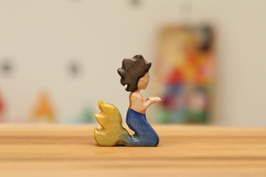 Kneeling Mermaid with short black curly hair and blue/yellow tail