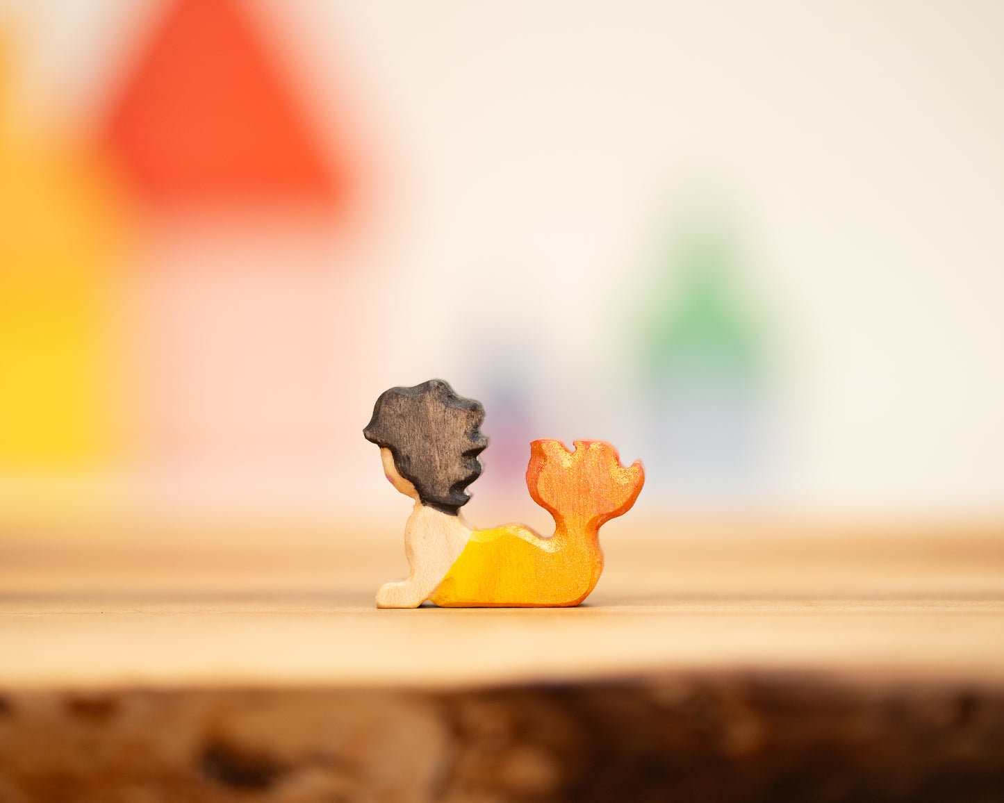 Reclining toddler mermaid with yellow/orange tail and black hair